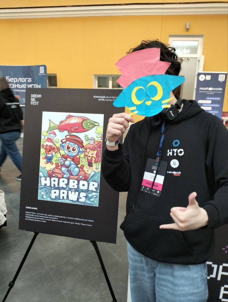 Участник возле постера игры «Harbor paws» во время финала